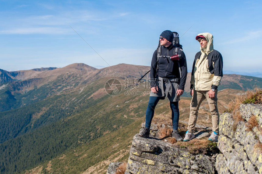 两个冒险家站在悬崖的边缘图片