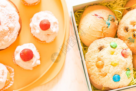 带奶油新鲜草莓和饼干盒装的端观纸杯蛋糕图片
