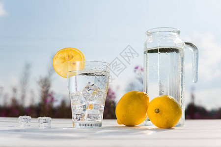 靠着一个装有水和两个柠檬的醒酒器图片