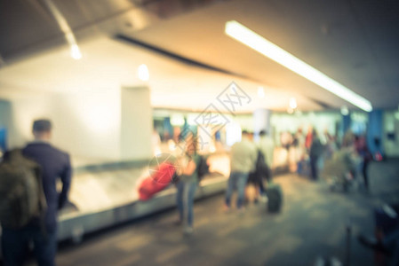 在旧金山国际机场行李认领区等待行李的不同乘客群体动作模糊传送带上的散图片
