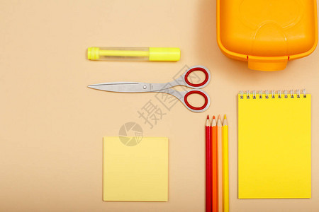 纸有感觉笔剪刀彩铅笔午餐盒和米色背景的笔记本图片