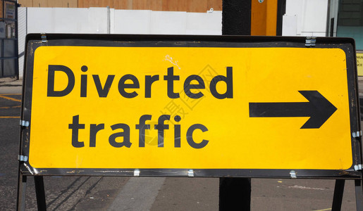 颠倒的交通方向标志黄色背景图片