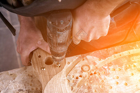 一名木匠在木制板上钻木板木制板上图片