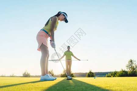 夏季与经验丰富的职业球员在高尔夫课上锻炼击球技术的漂亮身材的图片