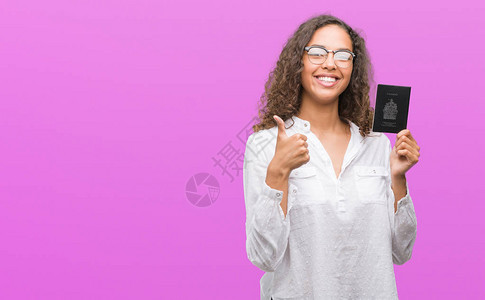 持有加拿大护照的西班牙裔年轻女开心地笑着做好手势图片