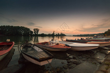 日落时在河岸停泊的小船图片