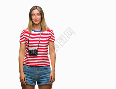 年轻漂亮的女人用老式相机在孤立的背景下拍照图片素材