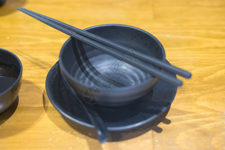 黑碗筷子和勺子的特写图片
