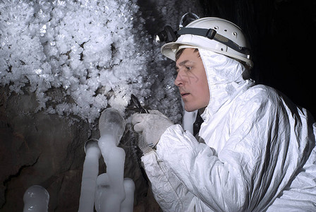 洞穴探险员通过放大镜仔细检查冰层结构a背景图片
