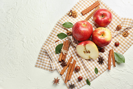 浅色背景中新鲜成熟的苹果和肉桂图片