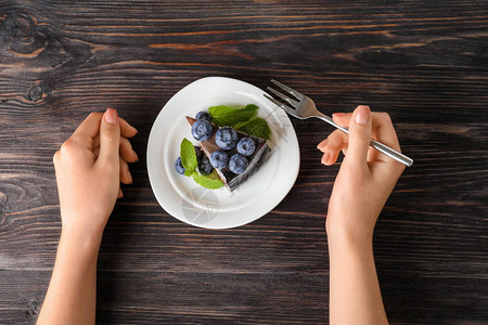 女人吃蓝莓巧克力蛋糕图片