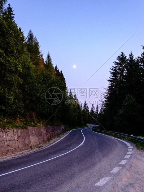 通往森林中山丘的沥青路面图片
