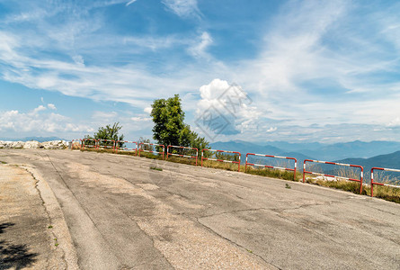 上坡的柏油路蓝天多云背景是群山背景图片