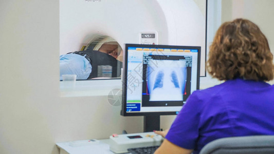 现代医院的MRICT扫描仪对老年患者进行扫描磁共振检查医生从控制室通过pc背景图片