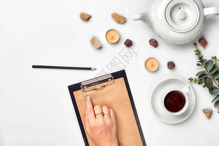 一个女人手在空书笔记日记传播模型顶视图工作室上写字杯咖啡休息时间笔记本中用于博客条目的空白间背景图片