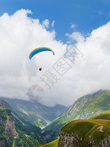 滑翔伞与准摩托机一起飞行在蓝色天空上看图片