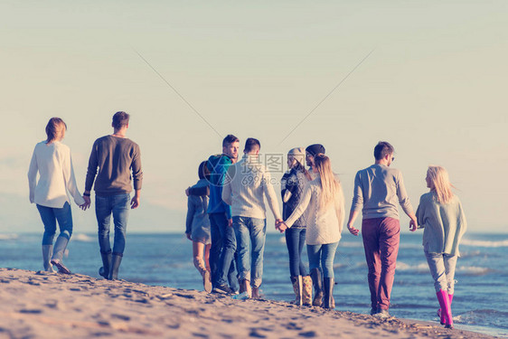 一群年轻朋友在秋天的沙滩上共渡一天在图片