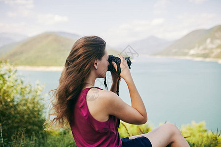 年轻的旅游女孩为山和湖拍照乔治亚州夏天八月拍摄山图片