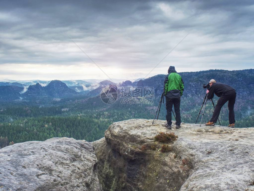 有才华的业余摄影师在岩石上拍照露营探险旅行和旅行