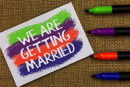 文字书写文本我们要结婚了订婚礼准备的商业概念爱的夫妇五颜六色的波浪与白页和文本颜色标记排图片