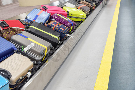 在机场客运终点站抵达地点的行李运输带上的手提箱和袋子图片