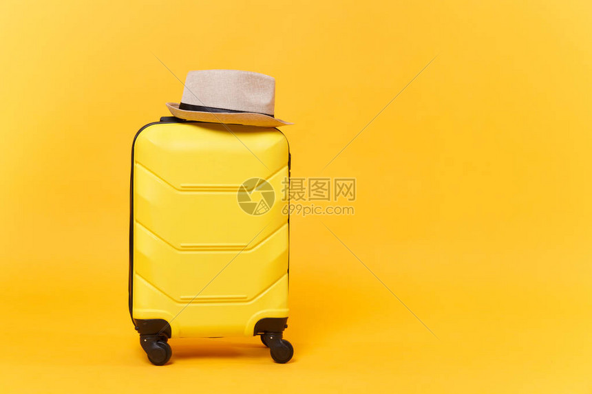 旅行游手提箱行李箱行李袋与夏季草帽隔离在黄色橙背景出国旅行的旅客用品配件旅行概念复制工图片
