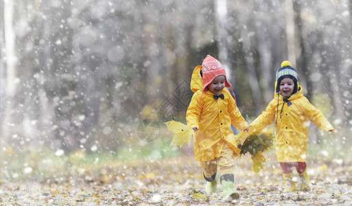 蹒跚学步的孩子们在秋天的公园里散步秋林初霜雪孩子们在公园背景图片