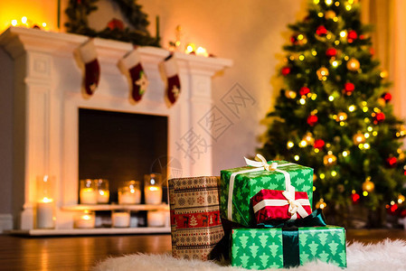 里的一些漂亮的圣诞礼物充满了冬季假期的魔幻气氛在温暖舒适的炉边用丝带装饰礼物圣诞节和图片