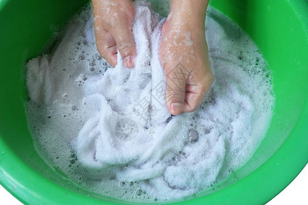 洗白毛巾衣服的手在盆子里用洗涤剂图片