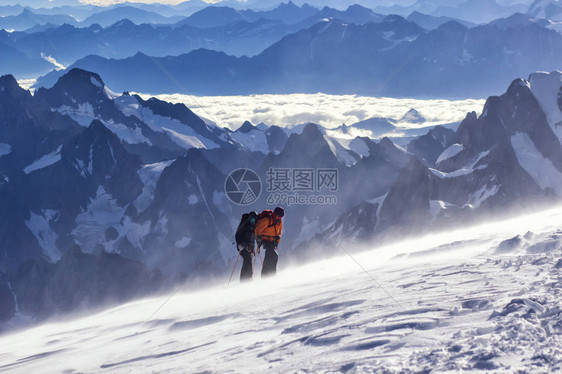 一群登山者爬上了一座雪山图片
