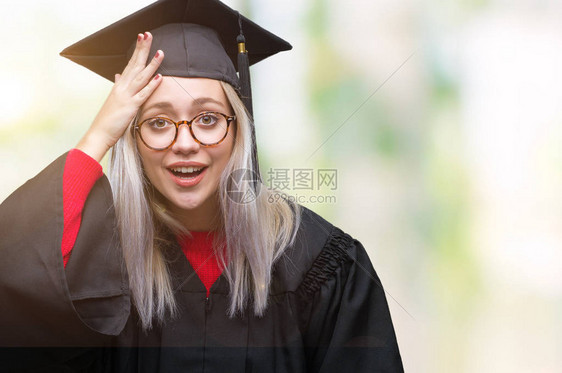 年轻的金发女子在孤立的背景下穿着毕业制服图片