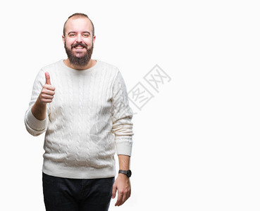 年轻的白种人时髦男子穿着冬季毛衣在孤立的背景下用手做着快乐的竖起大拇指的手势批准的表情看着图片