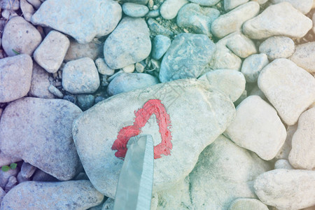 切割刀潜水粉红色的心在一块石头上涂口红爱的结束和两个人分手图片