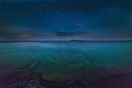 夜晚在格鲁吉亚湾湖岸边的银状冰雪和星空图片