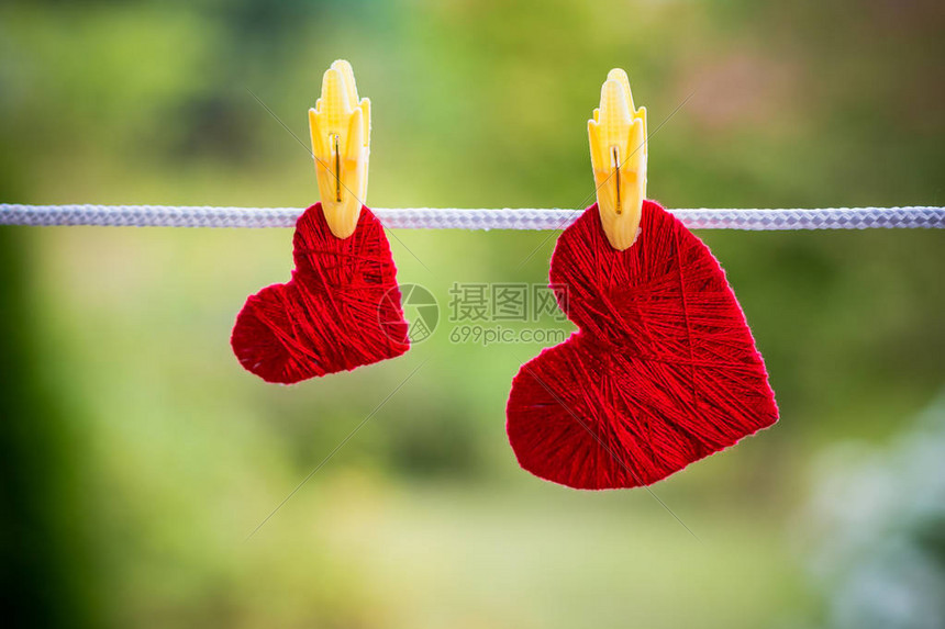 两颗红心挂在衣帽所固定的绳子上图片