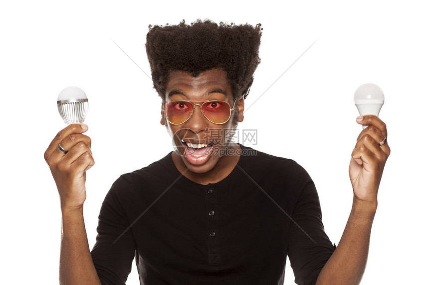 年轻英俊的非裔美国人拿着LED灯泡孤立在白色背景图片