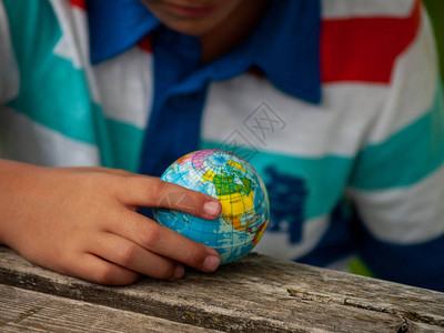 小朋友礼让一个拥有世界球或地球星的男孩在他的手背景