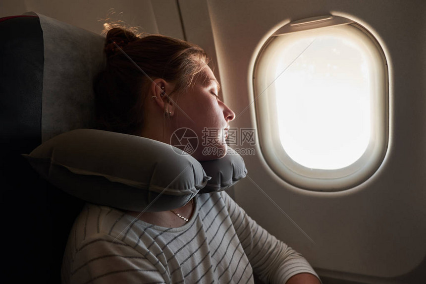 一个在飞机上睡觉的年轻女孩乘客睡在飞机上图片