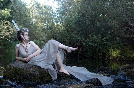 身着灰色丝绸礼服羽毛长袍和海蜗牛项链森林女神图片