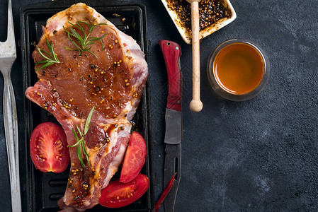 在烤盘上用香料蜂蜜和番茄腌制生羊排背景图片