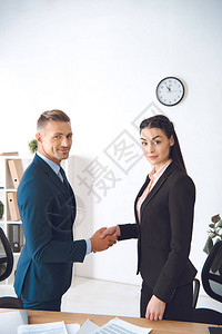 商业同事在办公室工作单位握手的一背景图片