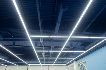 工业天花板漆成中蓝色灯以纵向和横向线的形式放置工商业场所的创意背景图片