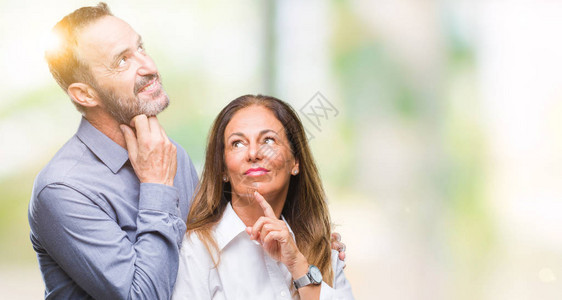 中年西班牙裔商业夫妇在孤立的背景下用手托着下巴思考问题背景图片