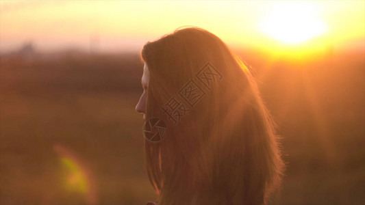 女人享受温暖的夏日落美丽的女人在图片