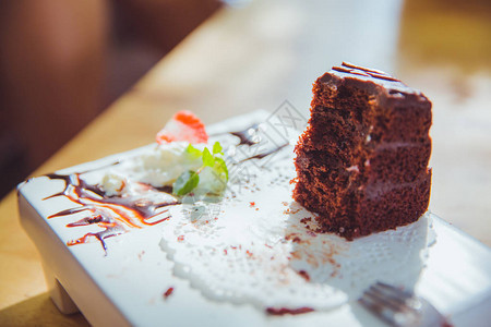在白盘上吃巧克力蛋糕图片