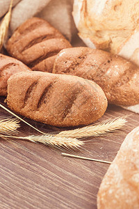 美味的新鲜烘焙产品木制背景上新鲜出炉的面包产图片