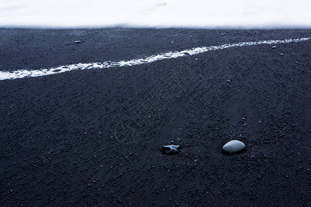 冰岛南海岸维克附近黑沙滩的图像冰岛南部黑色熔岩海滩上的白色泡沫冰岛图片