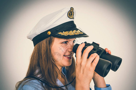 快乐的女船长拿着双筒望远镜海洋概图片