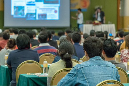 听众演讲者在会议厅或研讨会的舞台上展示幻灯片的后视图商图片
