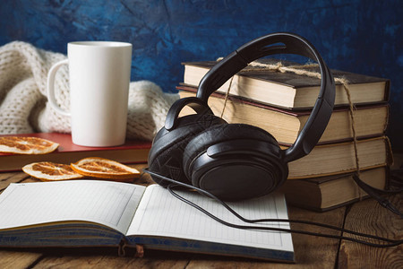 书库耳机白杯橙片木制背景的公开日记音频书籍和音图片